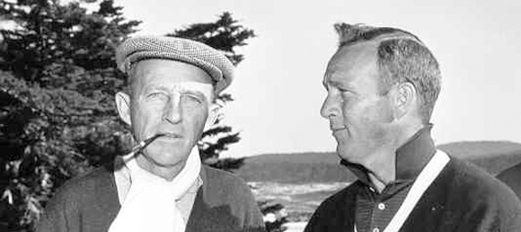 A black and white photo of two men (likely Bing Crosby and a companion) outdoors on a golf course. One man wears a flat cap and has a pipe in his mouth; the other is clean-shaven and wears a golf shirt.