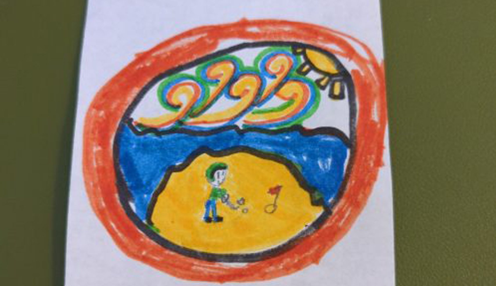A colorful child's drawing inside an orange ring, showing a person golfing on a sandy beach next to the blue ocean, with wavy, colored lines representing the sky and sun.
