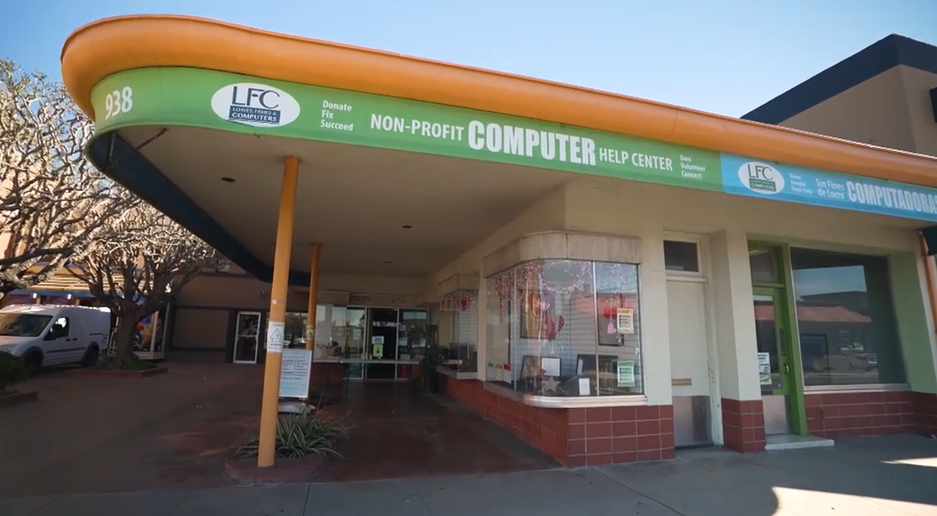The exterior of the Loaves & Fishes & Computers Non-Profit Computer Help Center, a low-slung building with an orange and green overhang, which was the 2022 PGA Tour Charity of the Year.